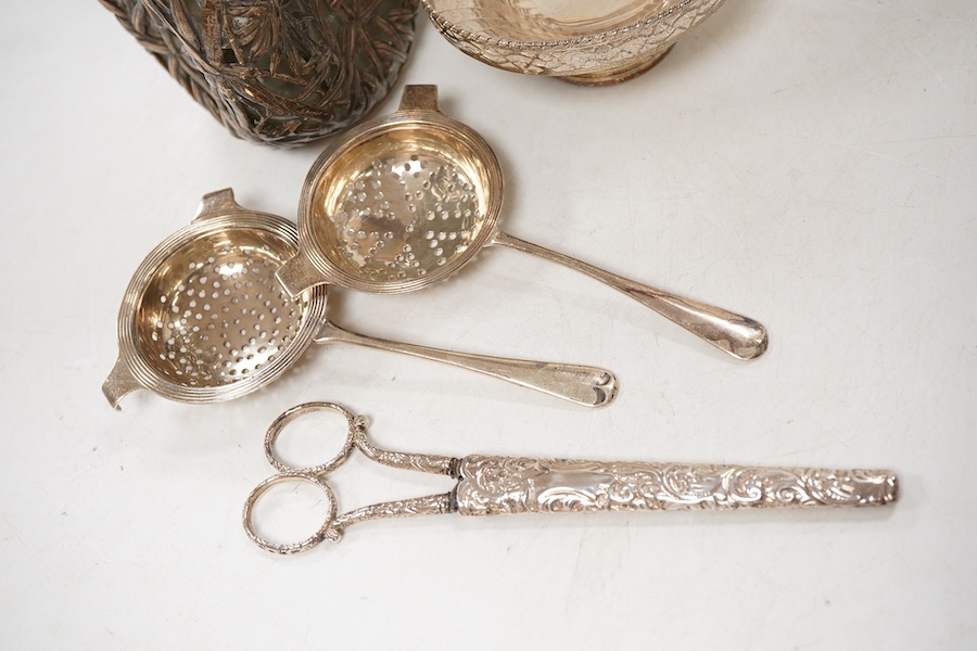 A Chinese sterling mounted dimpled glass decanter, with bamboo decoration, lacking stopper, approx. 19.5cm, together with a George V silver pedestal bonbon bowl, a pair of silver tea strainers by Roberts & Belk and a pai